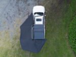 Rigdup 270 degree awning fully deployed over a white 4WD ute, aerial view showing full wraparound shade coverage