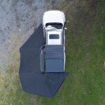 Rigdup 270 degree awning fully deployed over a white 4WD ute, aerial view showing full wraparound shade coverage