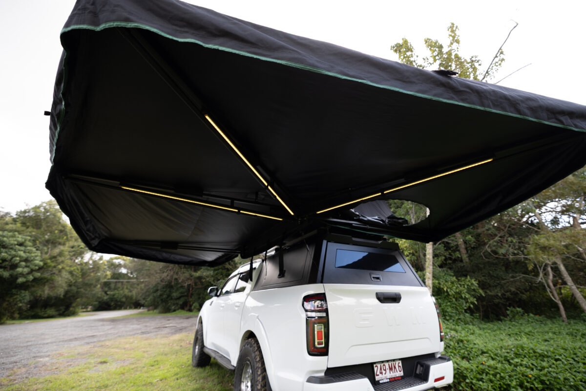 Rigdup 270 degree awning opened out over a white GWM ute, showing integrated LED light strips underneath